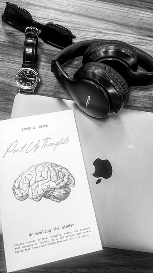 Pent Up Thoughts book styled with a watch, sunglasses, and headphones, poetry for anxiety and healing